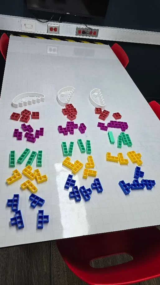 Estudiante mostrando piezas impresas en 3D listas para entrega